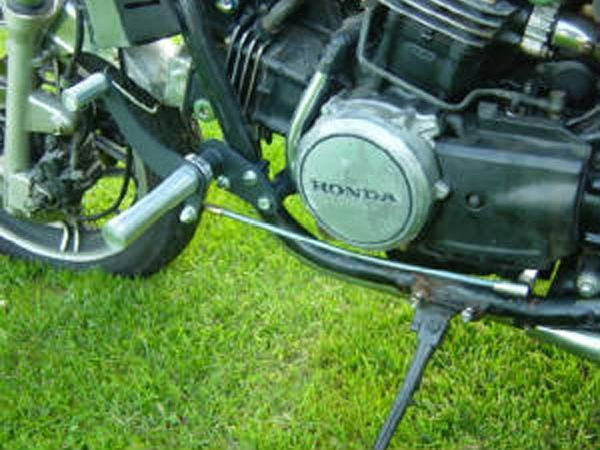 A TC Bros. Honda Magna V45 Forward Controls Kit motorcycle is parked on a grassy field.