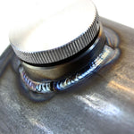 A close up of a TC Bros 5 inch Round Chopper Oil Tank Flat Ends Universal Fit flask with a metal lid, made in the USA.