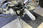 The TC Bros. Mid Controls Kit for 1991-2003 Harley-Davidson Sportster features metal foot pegs and a gear shift lever, perfect for upgrading your bike. Components are arranged on a white background.