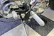 The TC Bros. Mid Controls Kit for 1991-2003 Harley-Davidson Sportster features metal foot pegs and a gear shift lever, perfect for upgrading your bike. Components are arranged on a white background.