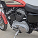 The TC Bros. Mid Controls Kit for 2004-2013 Harley-Davidson Sportster includes black brackets, silver foot pegs, bolts, nuts, washers, and a linkage rod from TC Bros., all arranged on a white background.