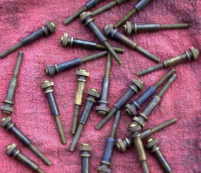 A group of Pangor Cycles All Thumbs Idle Speed Screws on a red cloth.