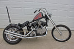 A TC Bros. black motorcycle parked in front of a garage.