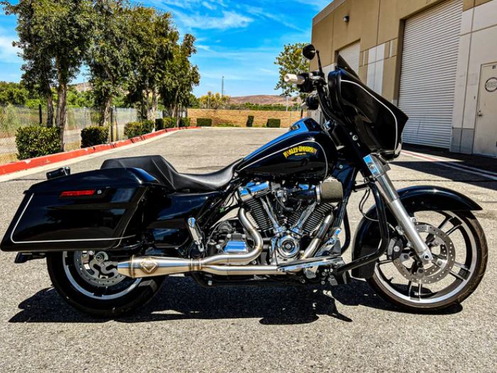 A black SP Concepts Lane Splitter Exhaust M8 Touring FLT 2017-Present (stainless) motorcycle parked in a parking lot.