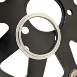A close-up of the TC Bros. 11.5" Rear Floating Brake Rotor for 2000-2023 Harley-Davidson, featuring a circular, perforated design with a black center hub and silver outer edge.