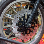 The TC Bros. 12.6" Oversized Front Floating Brake Rotors for 2000-Up Harley-Davidson wheels feature black centers, ventilated silver 420 stainless steel rings (one round, one wavy edge), and are ideal upgrades by TC Bros.
