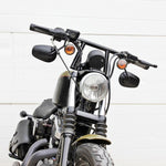 Two TC Bros. 1" Window Handlebars, one chrome and one black, featuring a distinctive rectangular center design inspired by TC Bros. Harley-Davidson styles, are displayed on a white background.