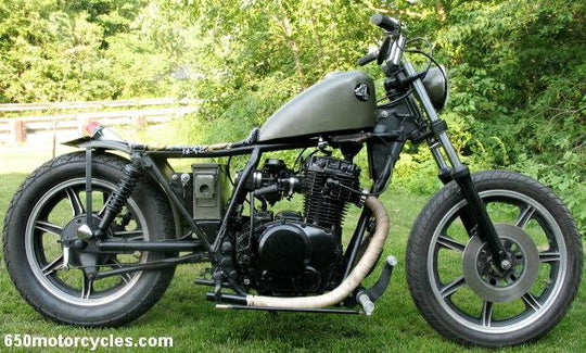 A TC Bros. motorcycle parked in the grass.