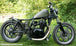 A TC Bros. motorcycle parked in the grass.