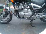 A silver TC Bros. Yamaha Maxim XJ750 Forward Controls Kit motorcycle parked in a driveway.